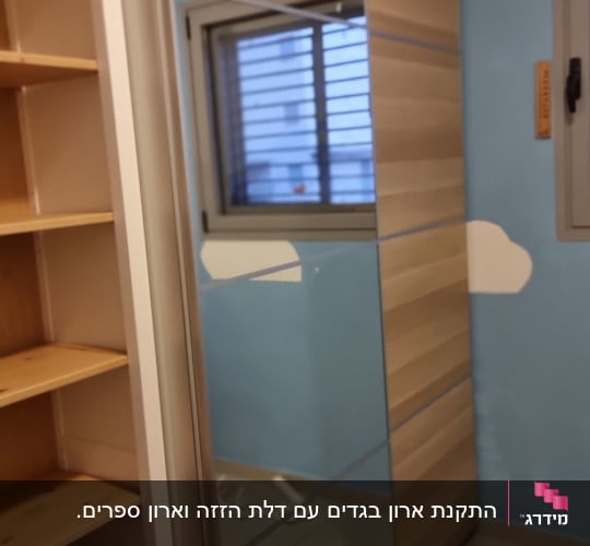 ארון עם מראה וחלון בחדר עם קירות כחולים